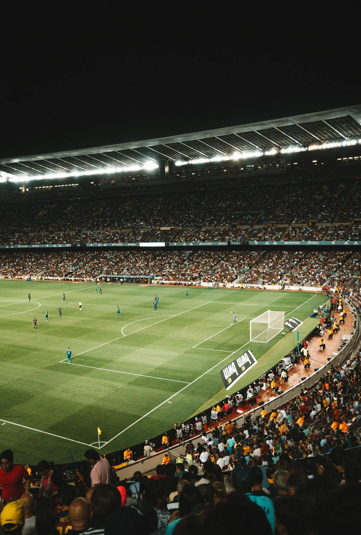 Floodlit football stadium packed with fans during a live match