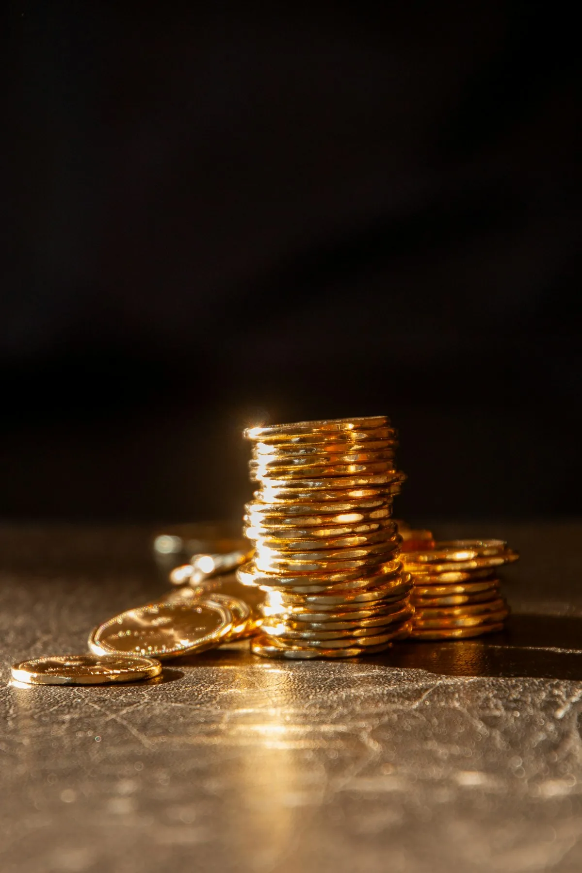 Pièces d'or empilées dans un éclairage sombre